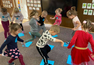 Zdjęcie przedstawia dzieci w trakcie zabawy na dywanie